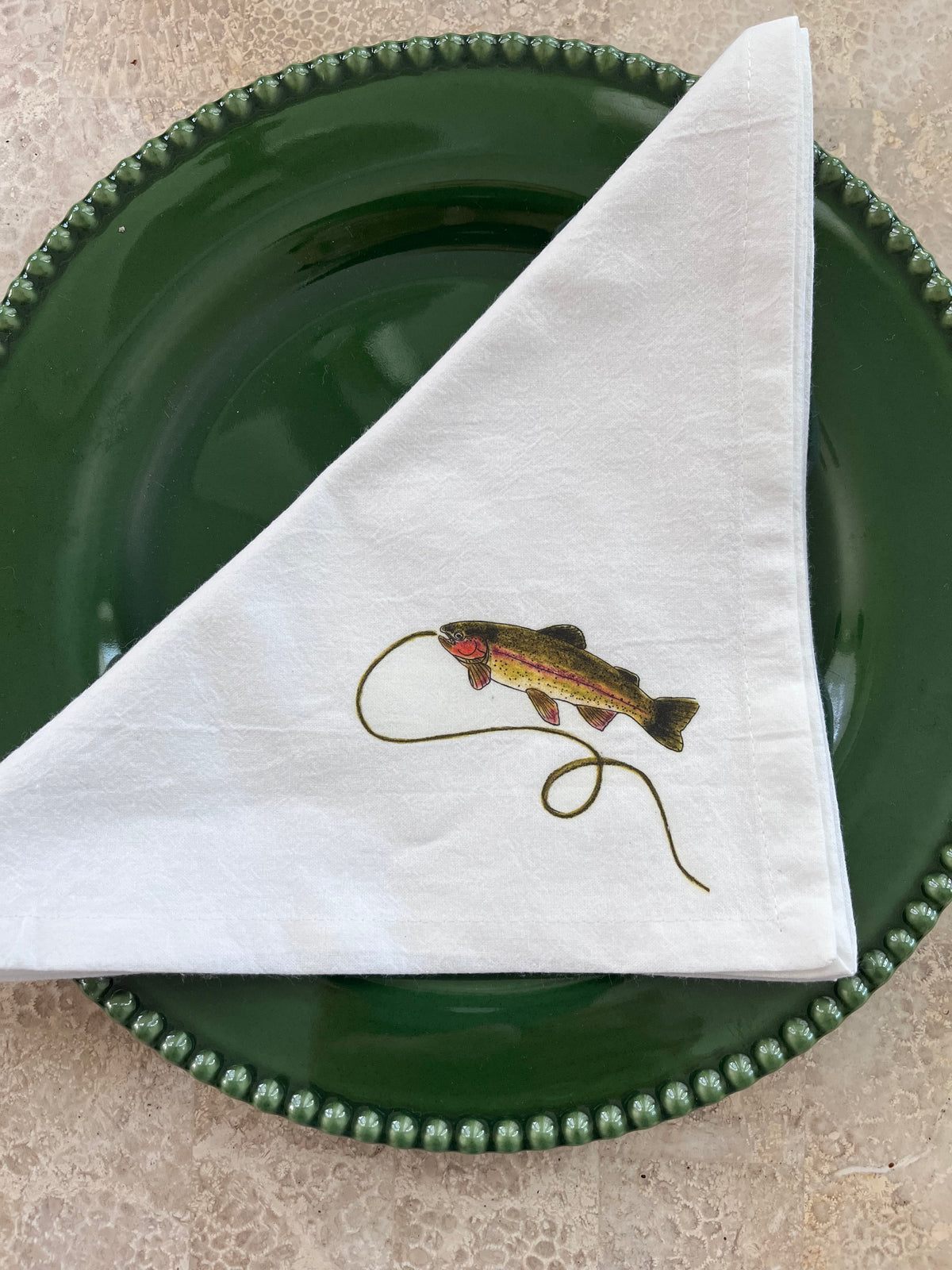 Nature-inspired cotton napkin with rainbow trout design, perfect for artful entertaining and gatherings.
