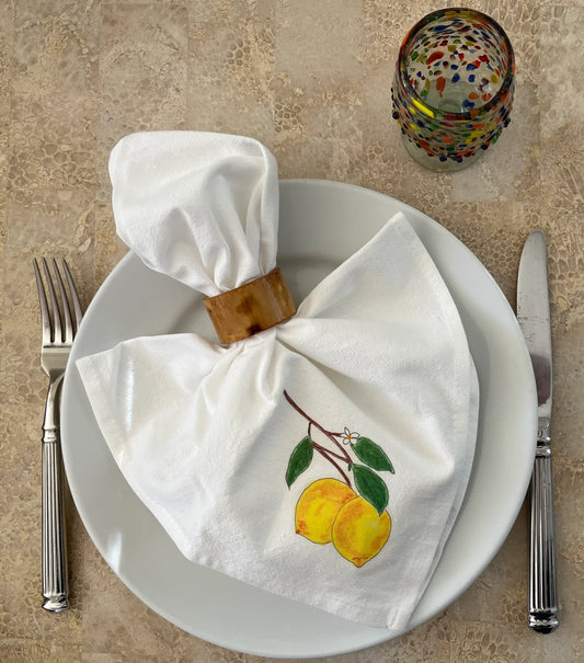 Illustrated lemon cotton napkin with napkin ring on plate, fork, knife, and colorful glass