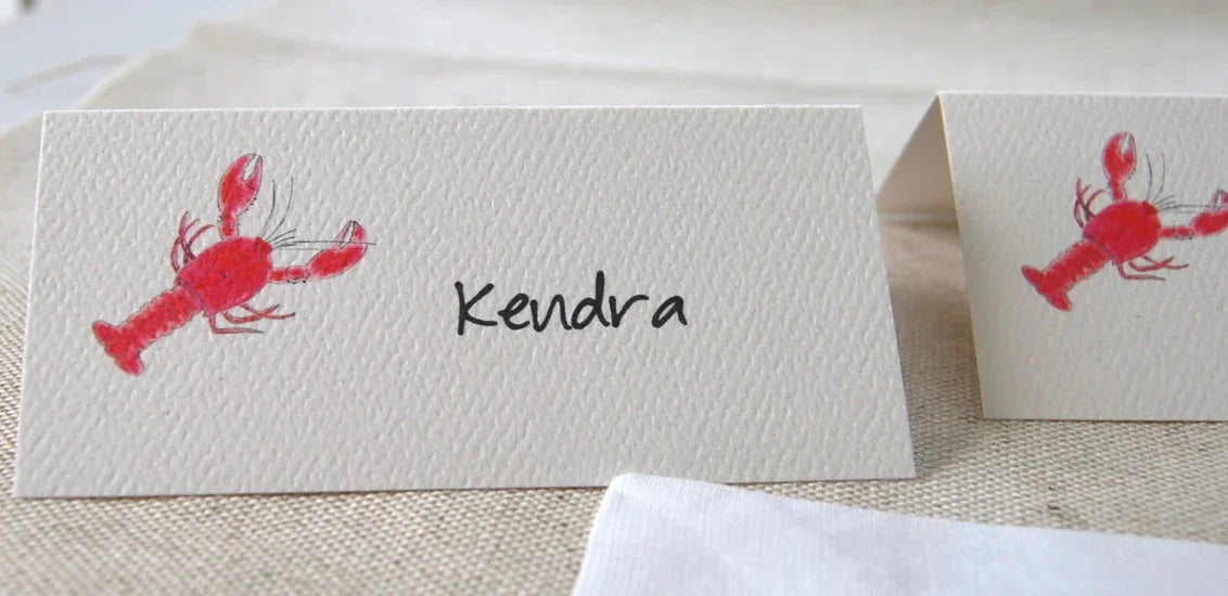 Handmade place card with red illustrated lobster and handwritten name, eco-friendly design