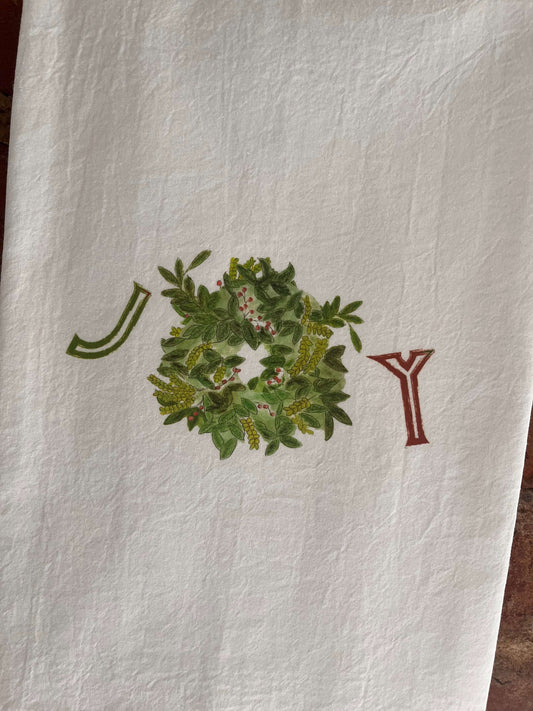 Nature-inspired tea towel with illustrated wreath, green leaves, red berries, and decorative letters J & Y