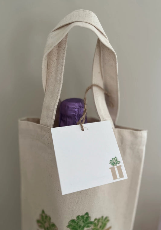 Eco-friendly canvas tote with plant illustration, bottle inside, and tag by Happenstance Creations