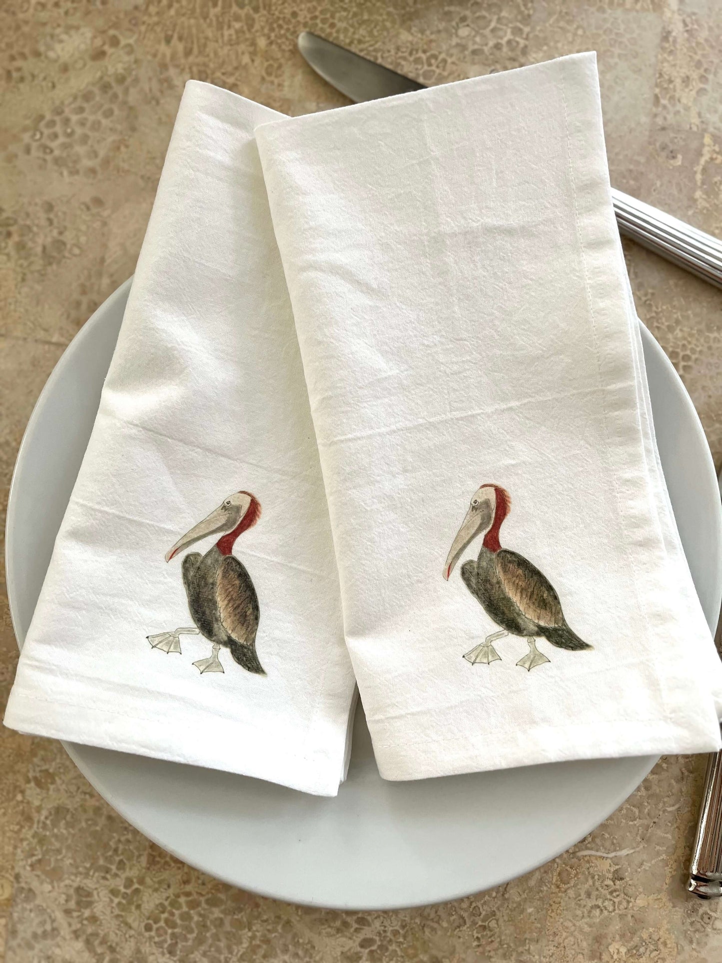 Pelican Napkin Set featuring elegant pelican illustrations on linen napkins, perfect for coastal-themed table decor.