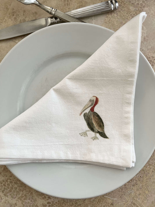 Pelican Napkin Set displayed on a plate, showcasing a beautifully illustrated pelican design.