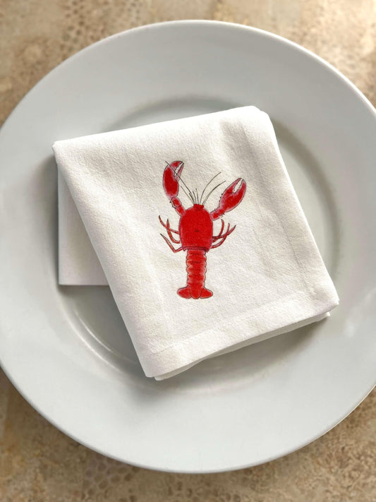 White cotton napkin with red lobster illustration on a white plate