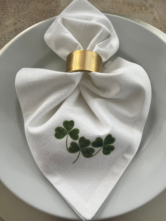 Shamrock Cotton Napkin Set elegantly arranged on a plate, featuring hand-illustrated shamrock design.