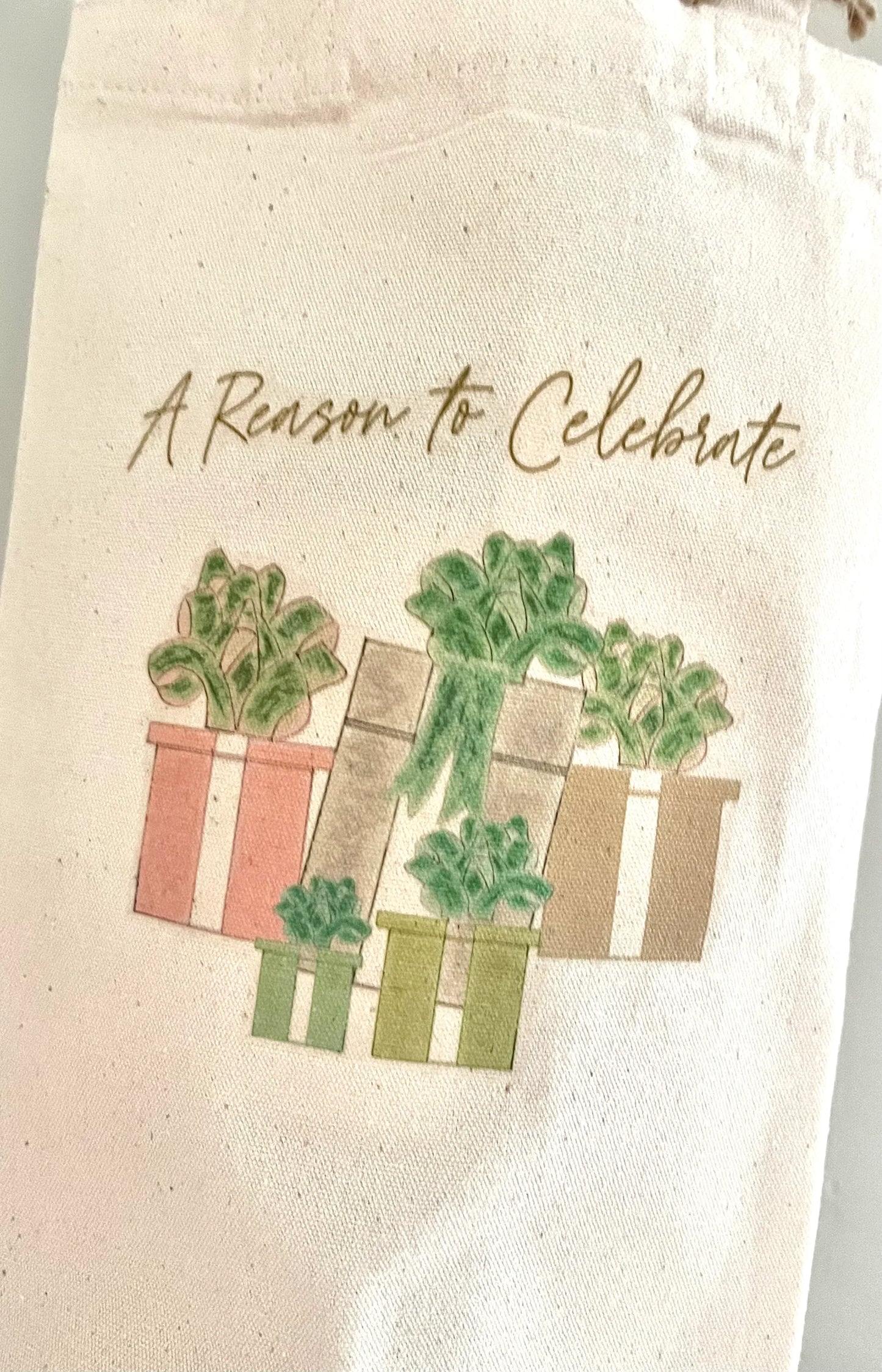 Natural canvas bag with 'A Reason to Celebrate' text and illustrated potted plants, perfect for gifts and gatherings.