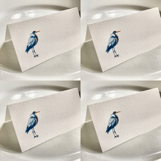 Hand-illustrated coastal bird place cards on textured white paper, eco-friendly event decor.