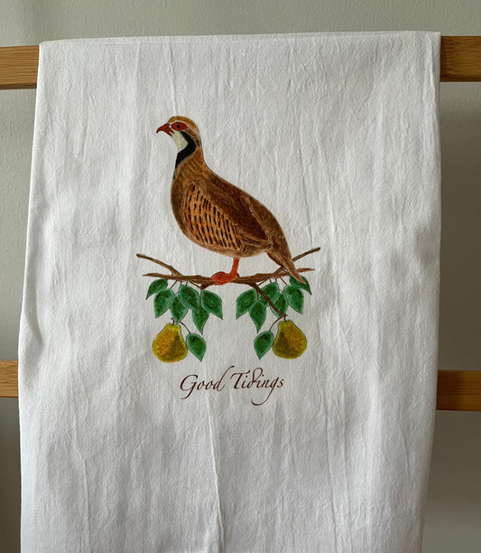 White tea towel with illustrated partridge on pear branch, 'Good Tidings' text, nature-inspired kitchen decor