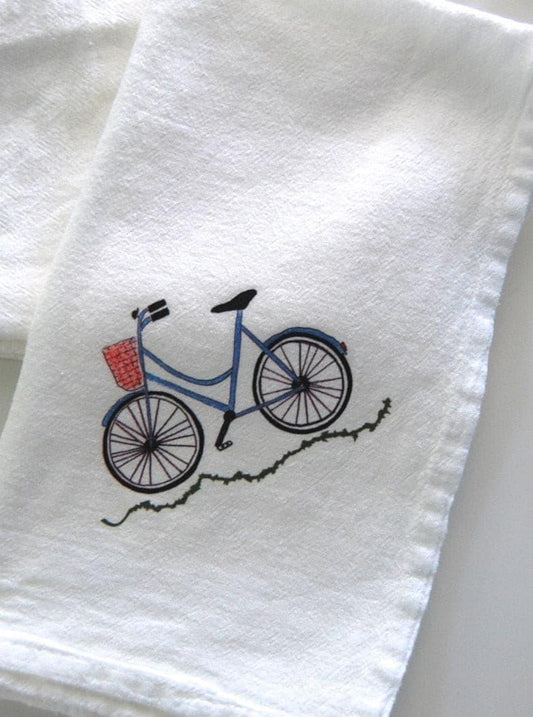 White tea towel with blue bicycle and basket illustration, eco-friendly kitchen decor