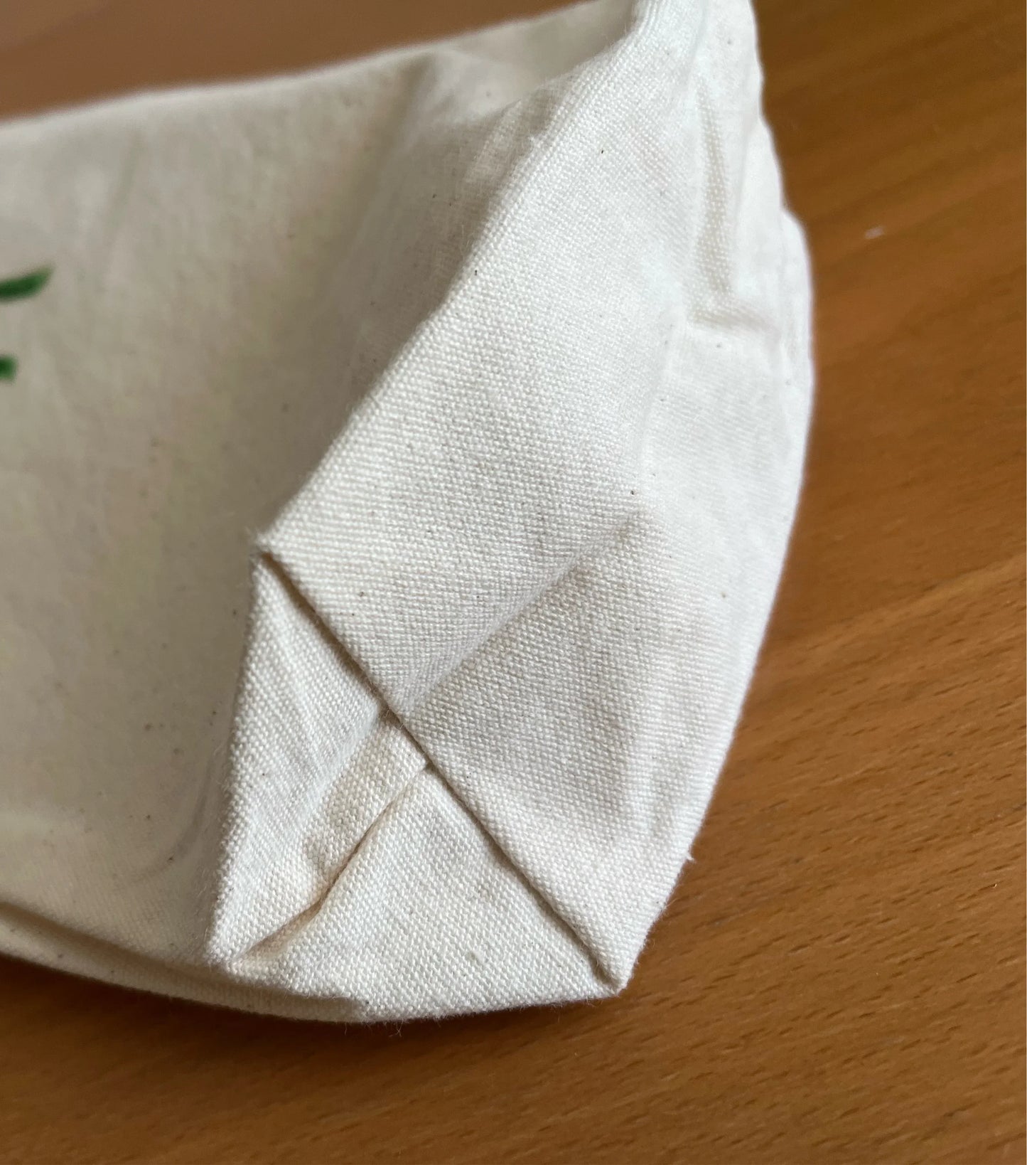 Close-up of eco-friendly canvas bag corner on wooden table, Happenstance Creations product