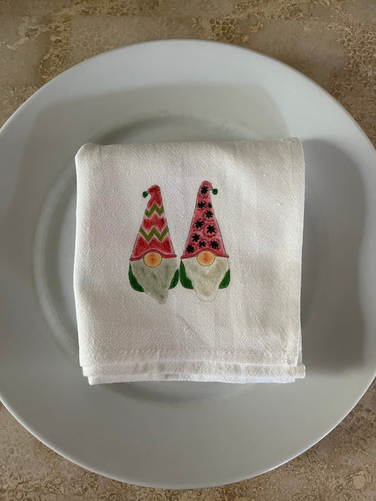 Festive gnome-print cotton napkin with holiday hats, perfect for holiday gatherings and table settings.