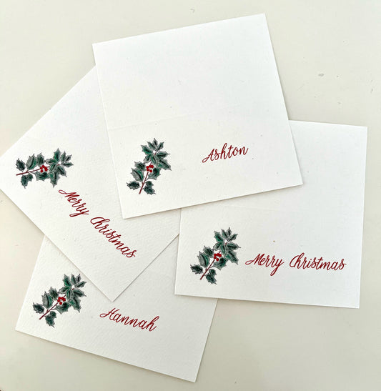 Holly-themed Christmas place cards with 'Merry Christmas' and names, perfect for holiday gatherings and festive table settings.