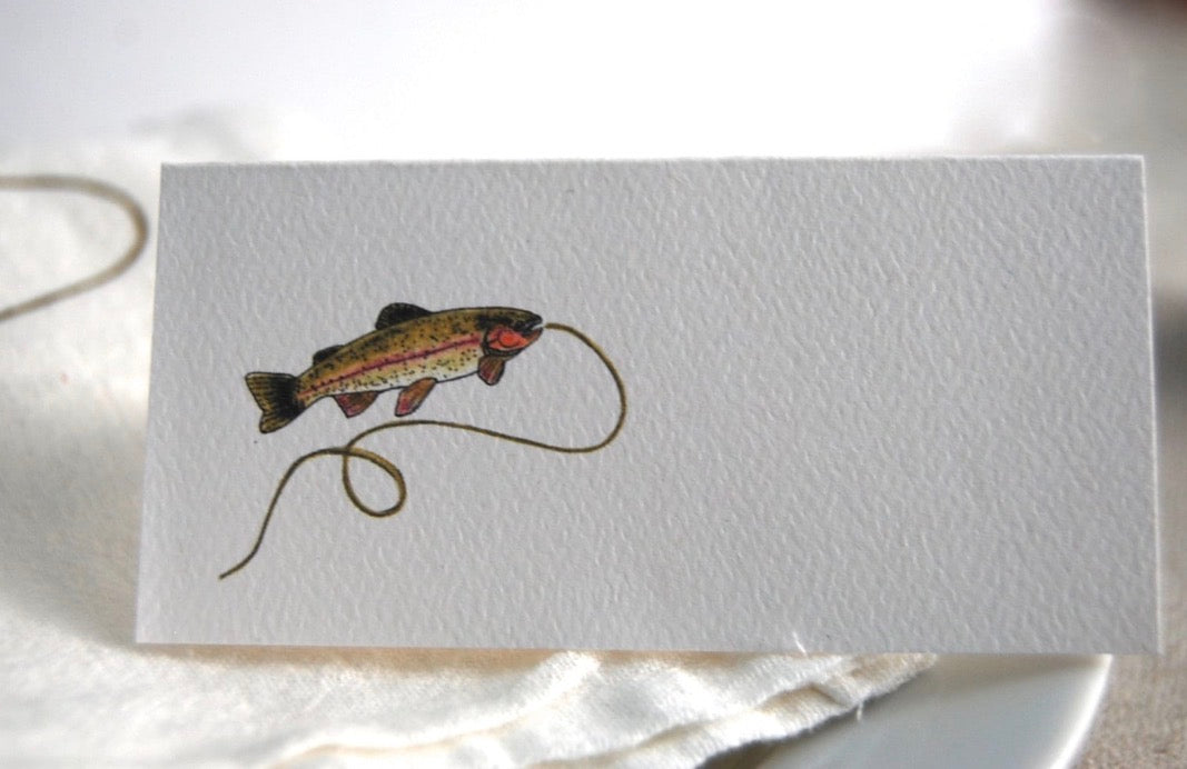 Illustrated rainbow trout on a tented name card for nature-inspired gatherings