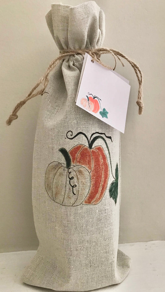 Burlap wine bag with pumpkins and a tag on a neutral background