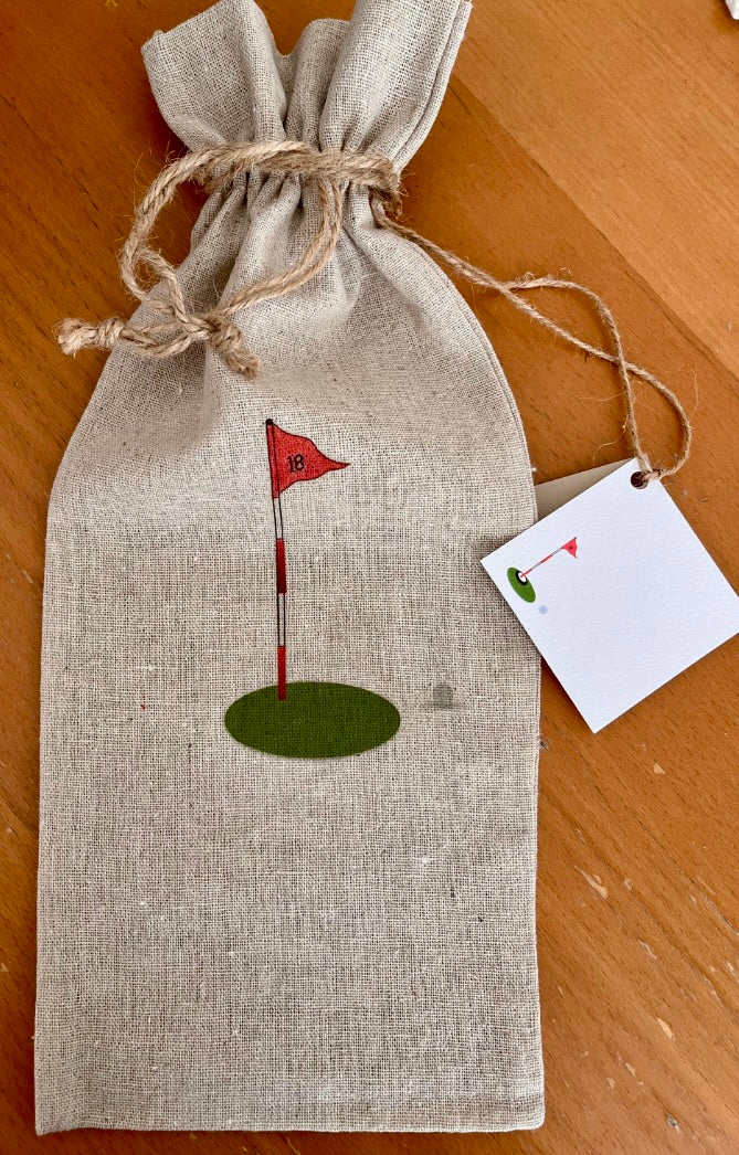 Linen gift bag with illustrated golf flag and green, tied with twine on wooden table