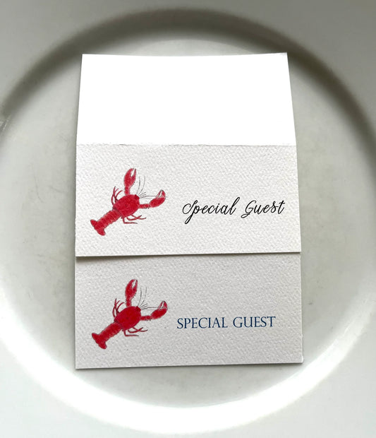 Lobster illustrated place cards with 'Special Guest' text on textured white paper plates