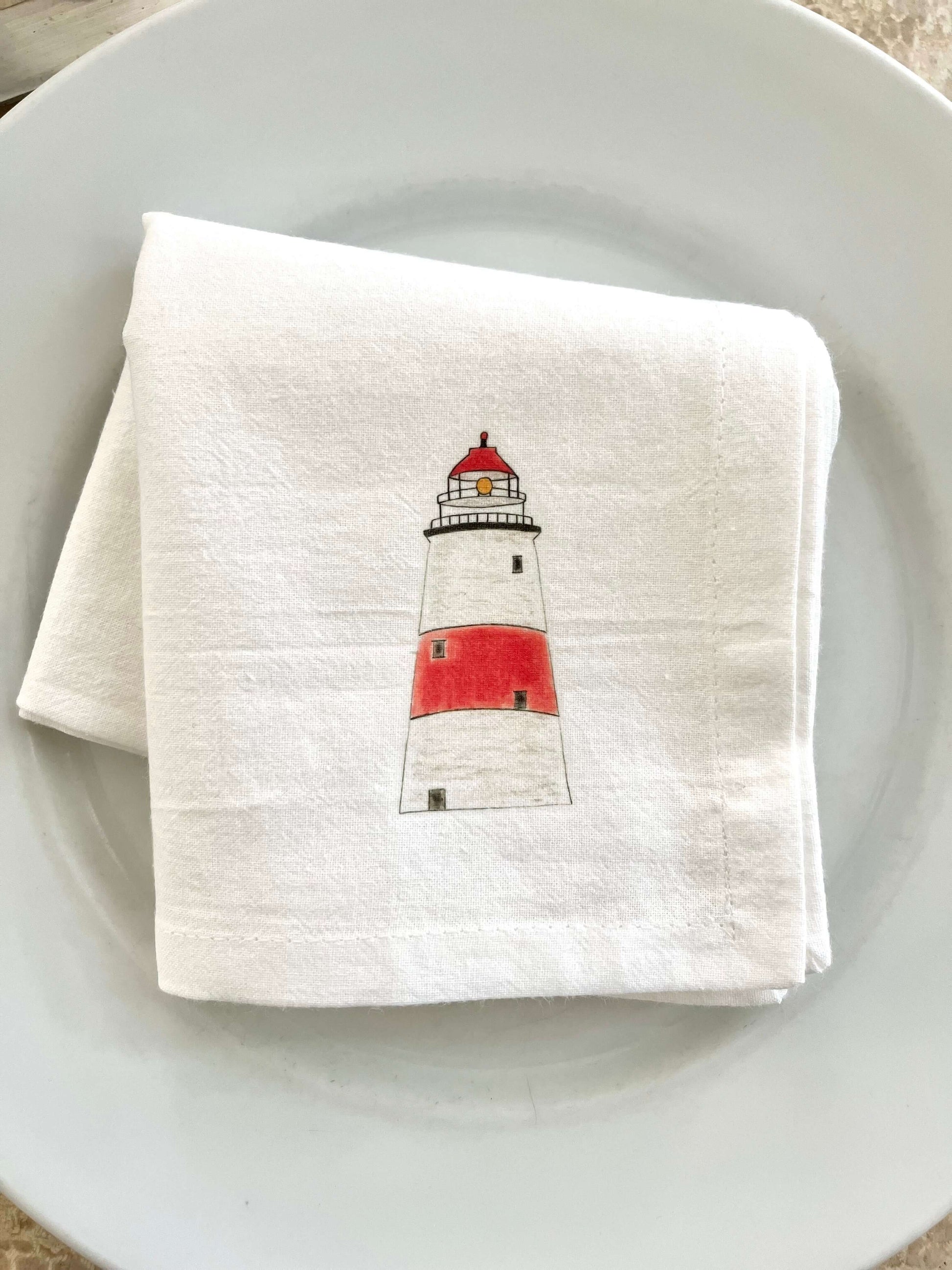 Lighthouse napkin set featuring hand-illustrated lighthouse design on a white cloth napkin.