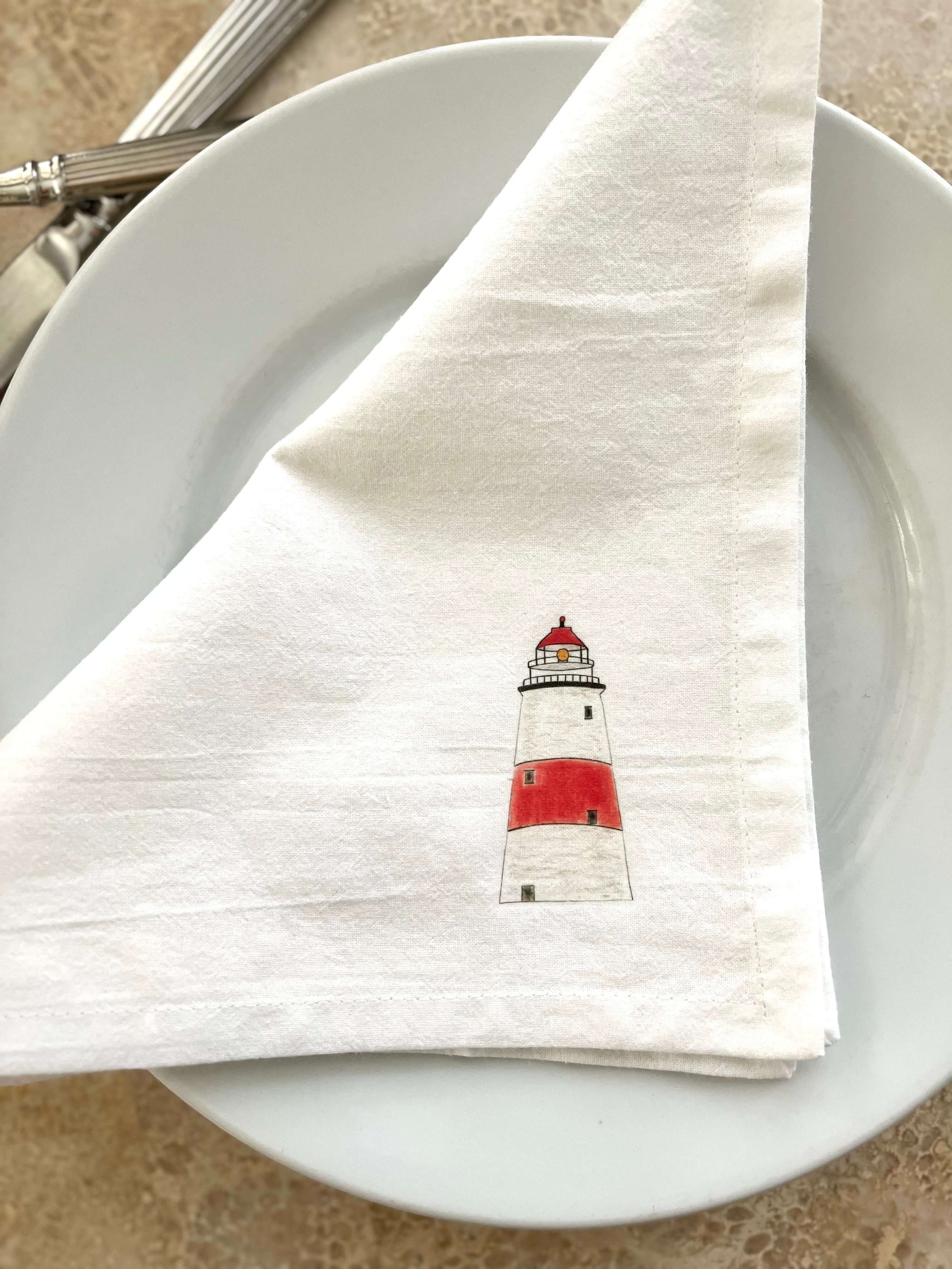 Lighthouse Napkin Set featuring hand-illustrated lighthouse design on a cloth napkin for coastal dining elegance.