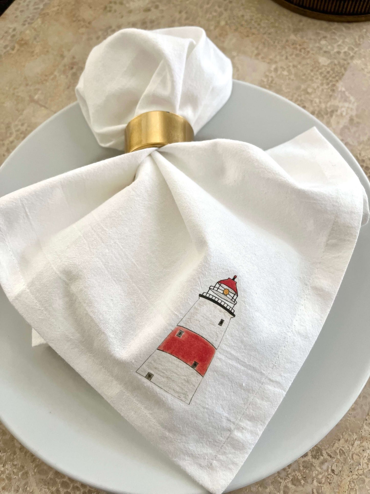 Lighthouse Napkin Set featuring hand-illustrated lighthouse artwork on a white napkin, perfect for coastal dining.