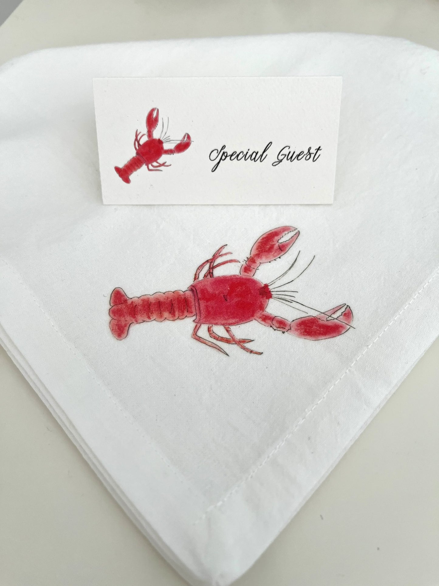 Red lobster illustrated on white cotton napkin with matching 'Special Guest' place card for coastal table settings