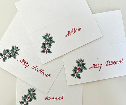 Holly-themed Christmas place cards with names and festive script