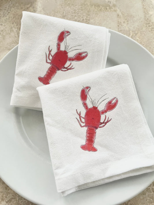 White cotton napkins with red lobster print, perfect for coastal or nautical table settings and gatherings.