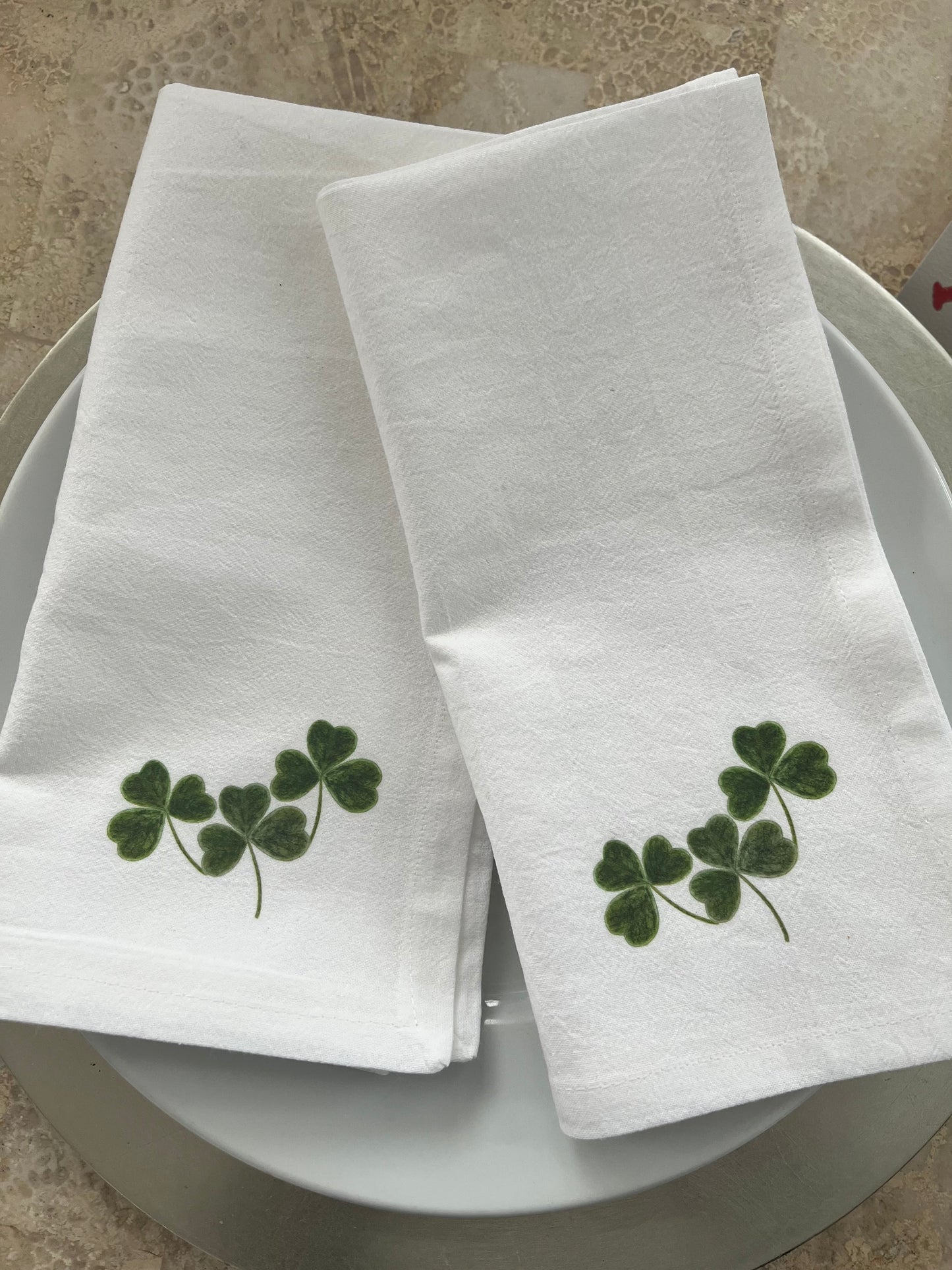 Shamrock Cotton Napkin Set featuring hand-illustrated green clover design on white cloth napkins for festive dining.