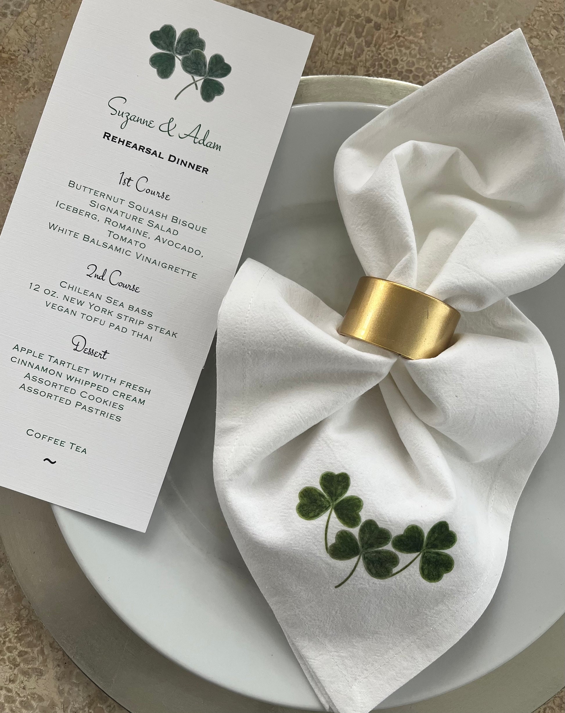 Shamrock Cotton Napkin Set elegantly tied on a plate for a rehearsal dinner, featuring a hand-illustrated shamrock design.
