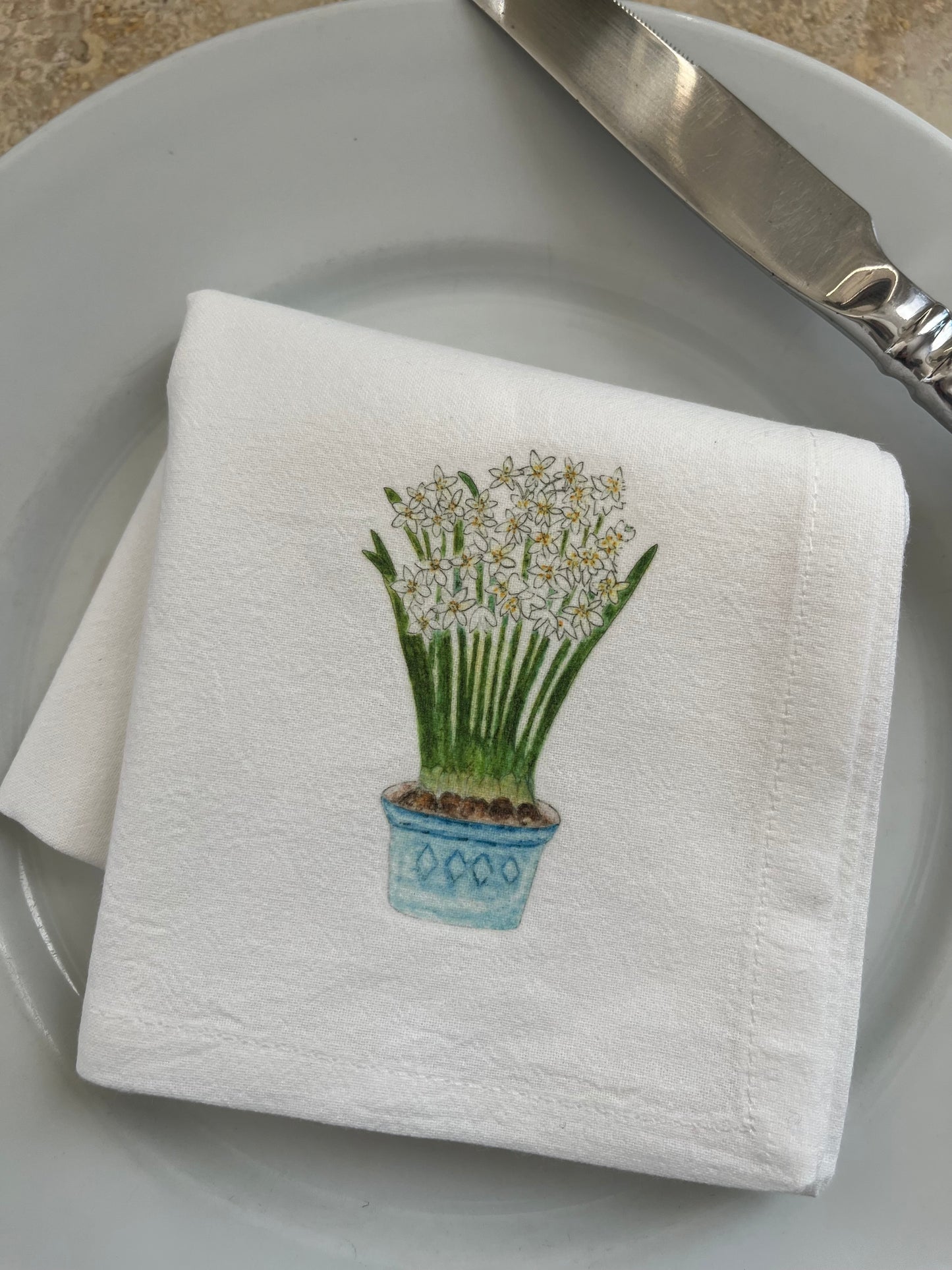 Cotton napkin with illustrated potted white flowers on a plate, table setting decor
