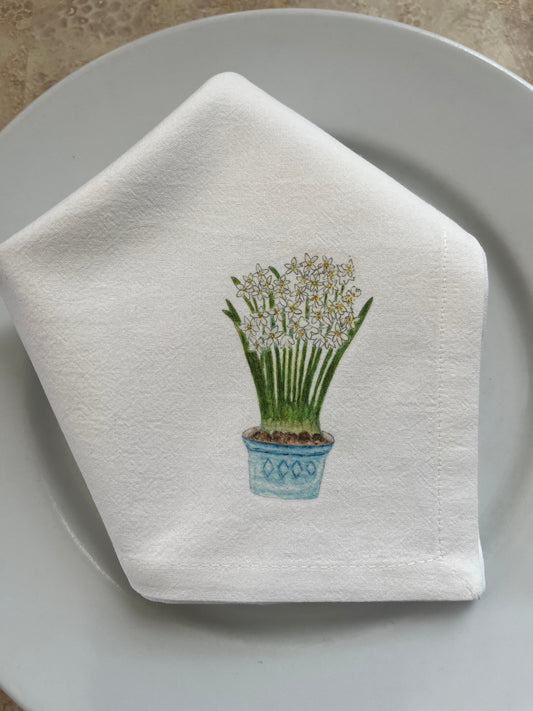 Cotton napkin with illustrated potted white flowers on a white plate, nature-inspired design