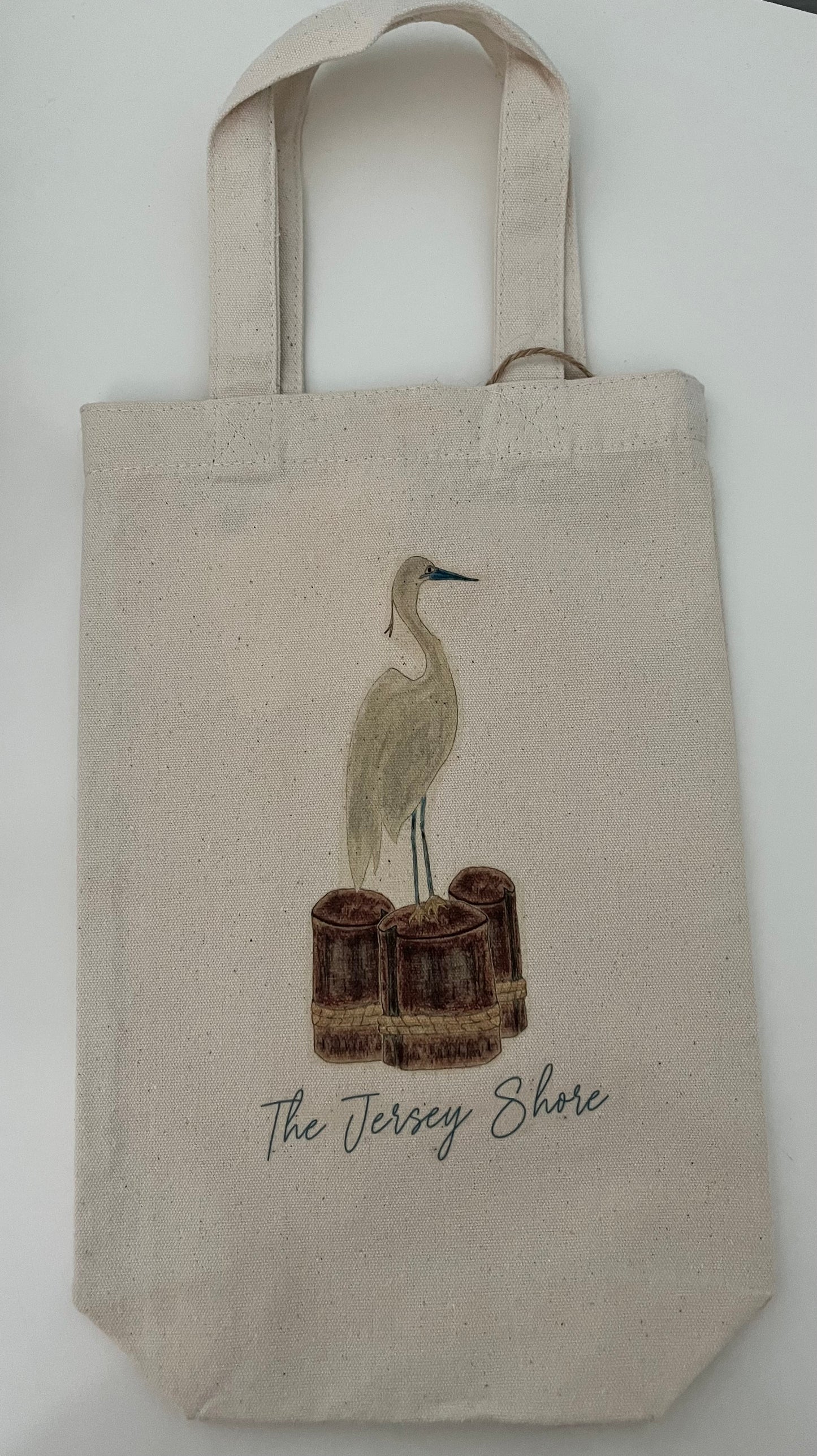 Canvas tote bag with illustrated heron, wooden pilings, and The Jersey Shore text