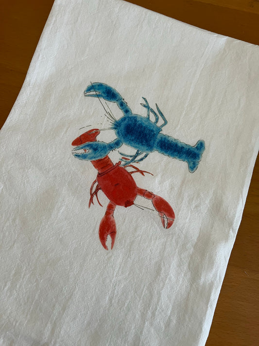 Illustrated tea towel with blue and red lobster design on white cotton fabric.